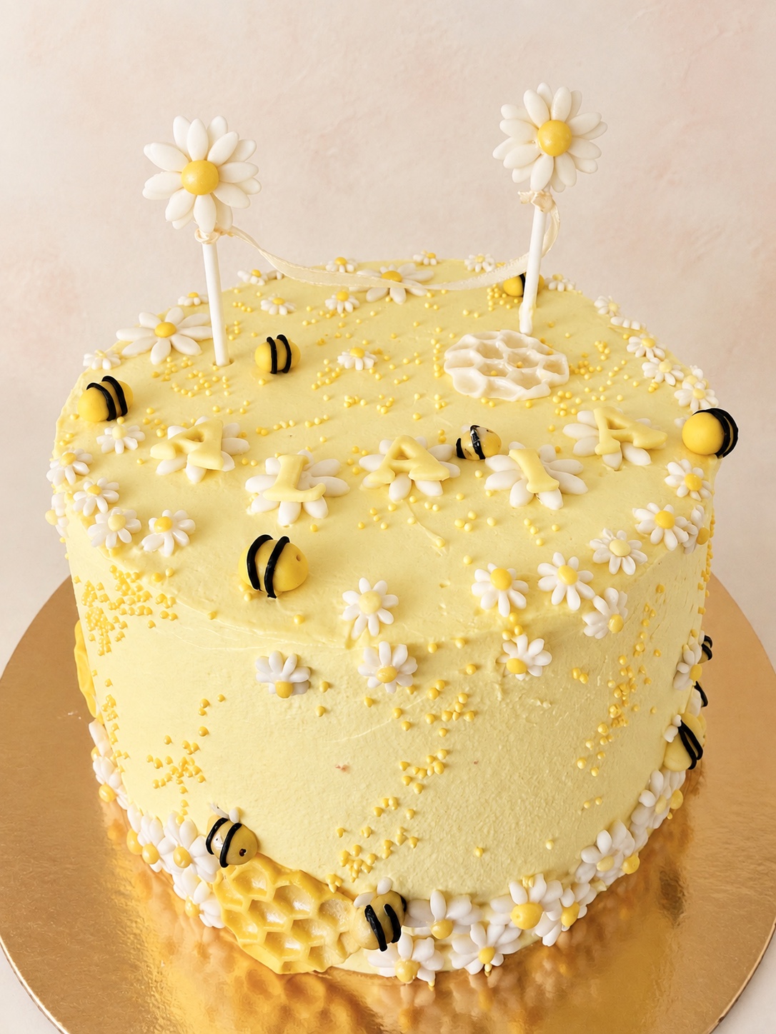 Tarta personalizada alta amarilla con abejas y margaritas