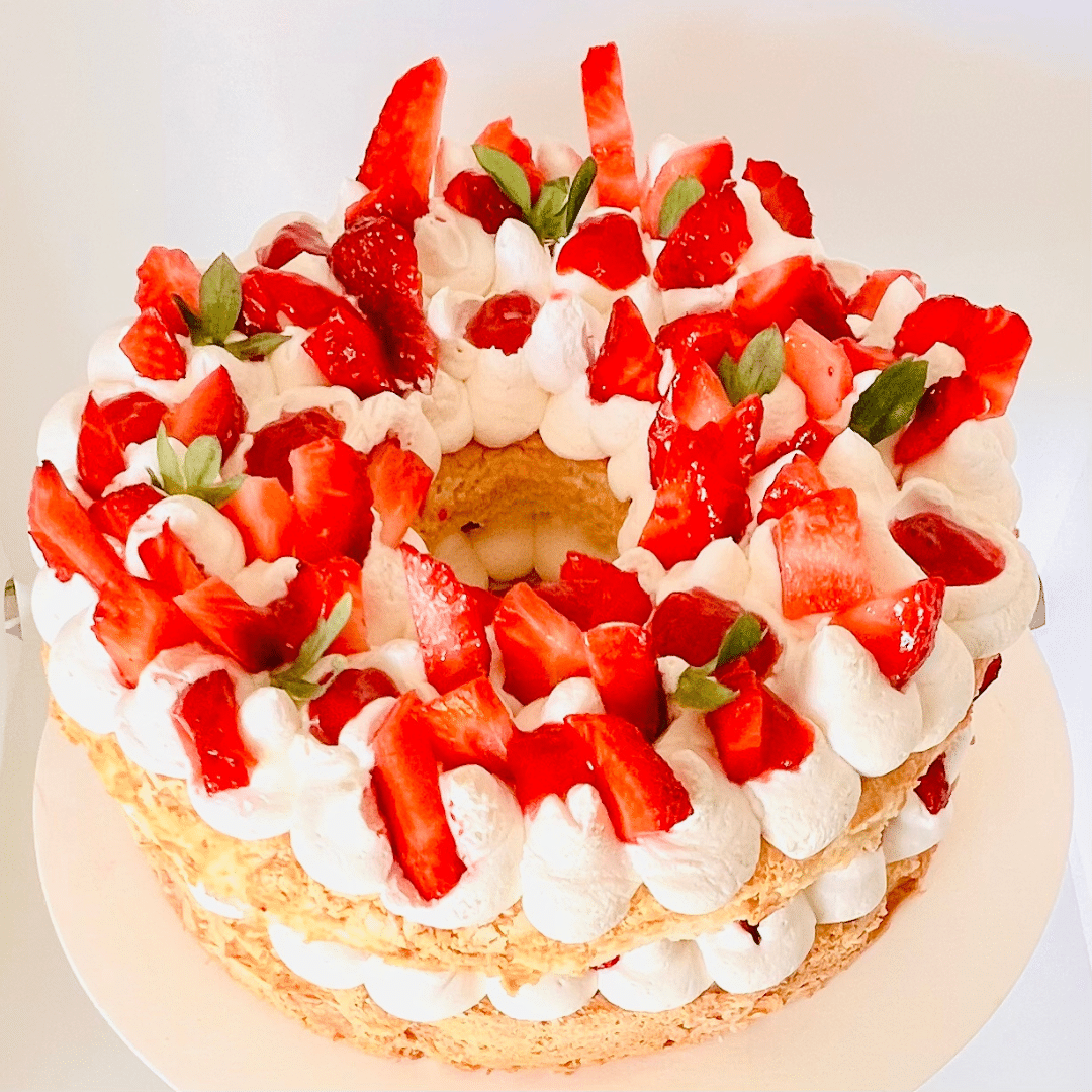 Disfruta de nuestro delicioso pastel de bizcocho blanco, conocido por su textura increíblemente ligera y esponjosa, resultado de estar hecho principalmente con claras de huevo. Relleno de una suave crema y fresas frescas