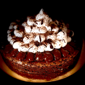 Disfruta de nuestra tentadora creación: un delicioso bizcocho de chocolate con nueces, donde la combinación perfecta de textura y sabor te dejará cautivado. Con una superficie crocante que contrasta con su interior cremoso, cada bocado es una experiencia indulgente. Además, está coronado con una generosa capa de merengue y adornado con delicados hilos de chocolate, añadiendo un toque irresistible a este placer gastronómico.