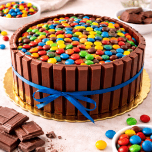 Bizcocho de Chocolate, húmedo y esponjoso relleno con dulce de leche. Recubierta de Chocolate KitKat y M&M.