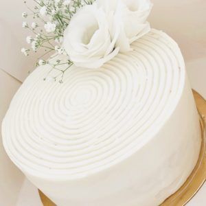 Bizcocho de Vainilla, húmedo y esponjoso relleno y decorada con una crema de queso suave y cremoso, que hacen una combinación exquisita. Esta tarta lleva como decoración un pequeño arreglo floral natural (según la estación del año varian las flores)