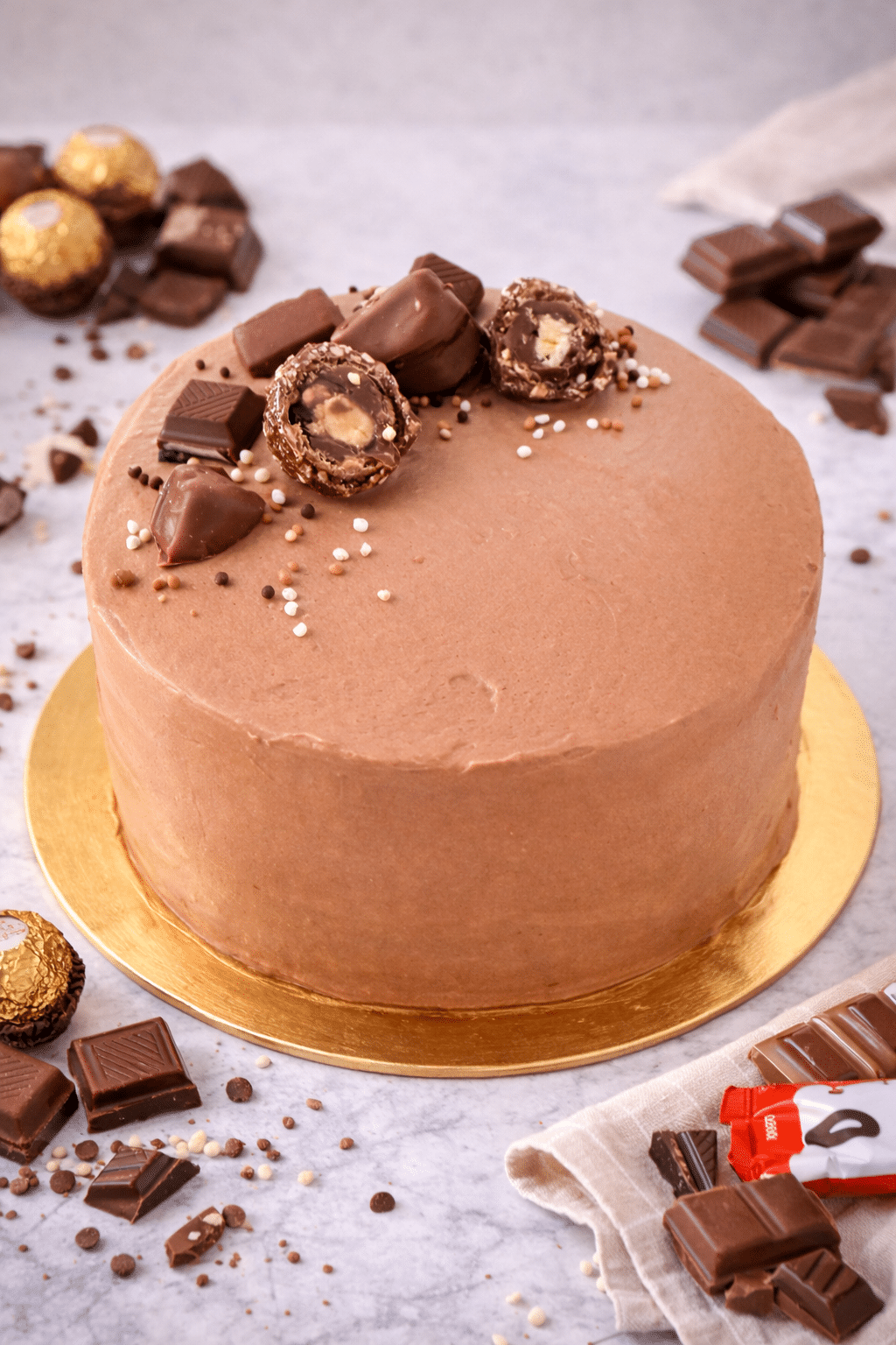 La Tarta de Chocolate y Más Chocolates es el sueño hecho realidad para los amantes del cacao. Su base es un bizcocho tierno, esponjoso y extra húmedo, que puede ser de chocolate o vainilla según tu preferencia. Cada capa está rellena con una mousse de chocolate suave y cremosa, y recubierta con una generosa selección de chocolates variados que aportan texturas y sabores irresistibles. Es una tarta intensa, golosa y elegante, ideal para celebraciones, regalos o simplemente para darte un capricho inolvidable.