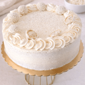 La Tarta Raffaello es pura elegancia: suave, delicada y con una mezcla irresistible de crema, almendra y coco. Coronada con bombones Raffaello caseros, es tan deliciosa como hermosa.